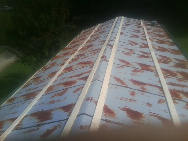 Rusted metal roof panels with new wood purlins before replacement — Storm Damage Roof Repair in Orwigsburg by Roofing Brothers