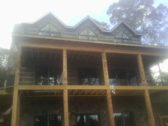 Dormers and porch framing on a large log home under construction — Roof Coating work by our crew in Orwigsburg